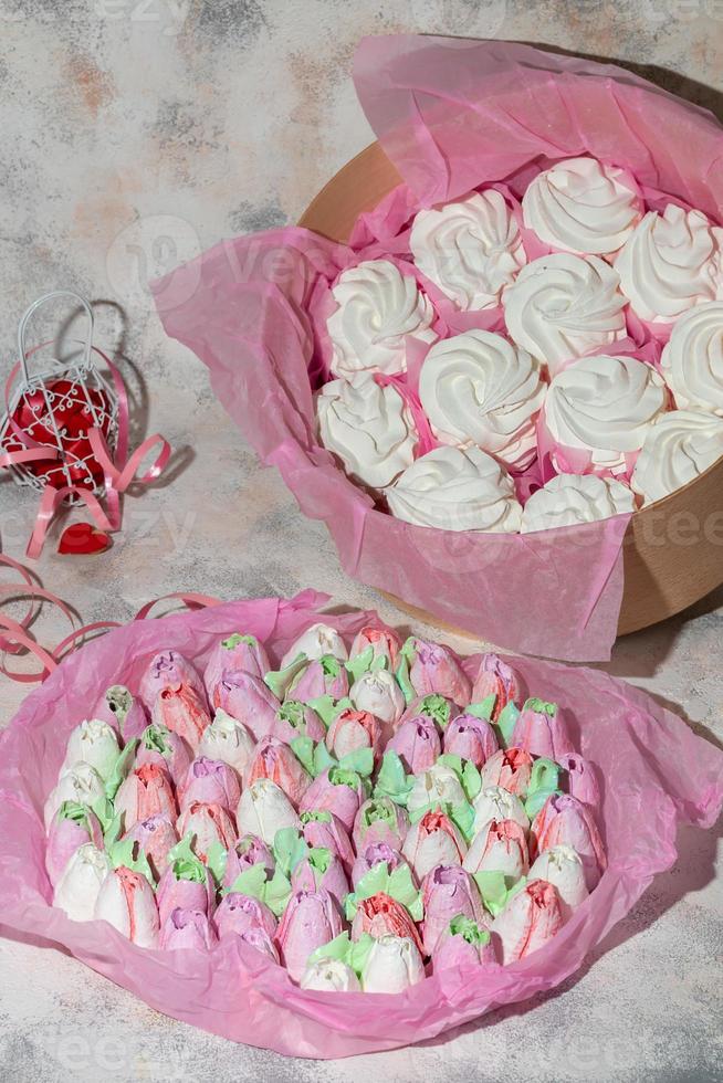 Handmade marshmallows in wooden packages on a light background with flowers. The concept of the holidays Women's Day and Valentine's Day. photo