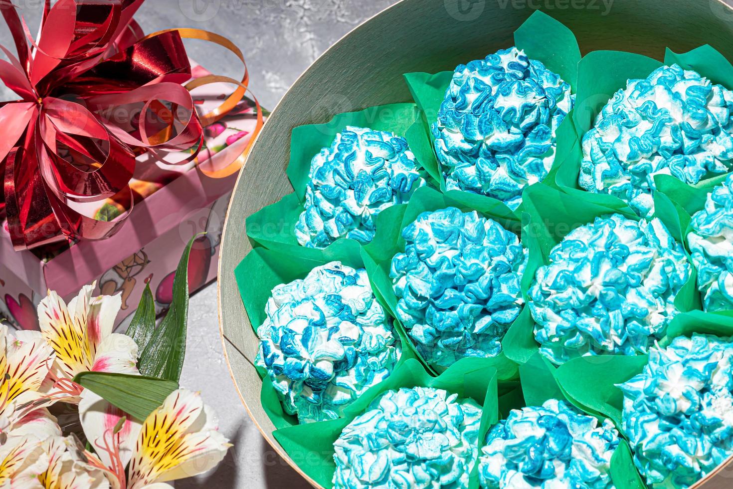 Handmade marshmallows in wooden packages on a light background with flowers. The concept of the holidays Women's Day and Valentine's Day. photo