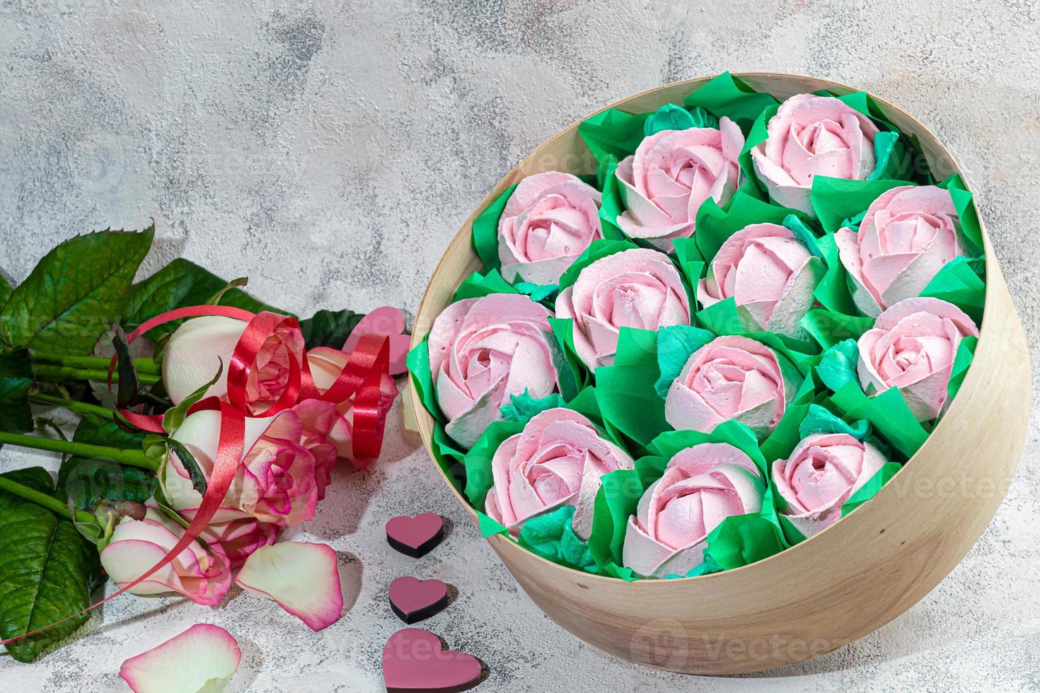 Handmade marshmallows in wooden packages on a light background with flowers. The concept of the holidays Women's Day and Valentine's Day. photo