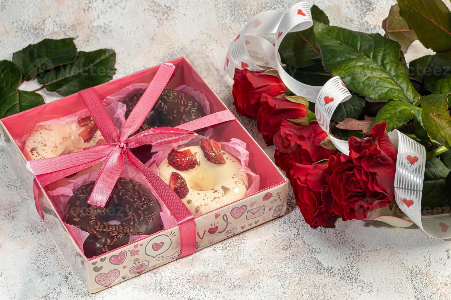 Handmade donuts on a light background in white and black chocolate. There are flowers nearby. Women's day, Valentine's day. photo