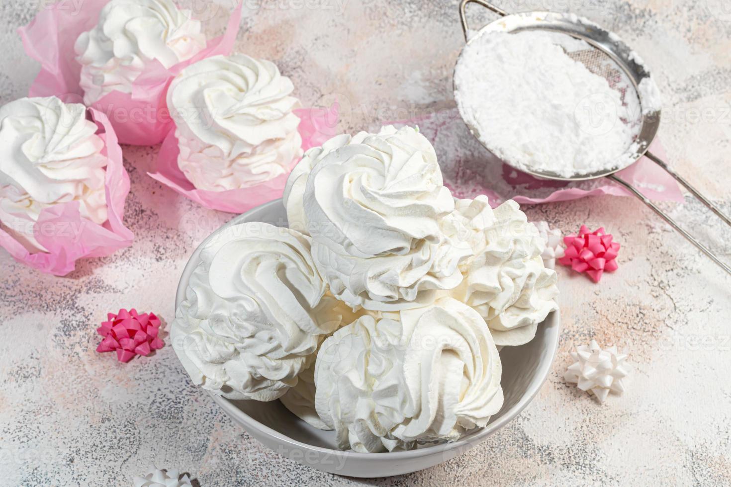 Handmade marshmallows on a light background in the form of roses, hydrangeas and tulips. There are flowers nearby. Women's day, Valentine's day. photo