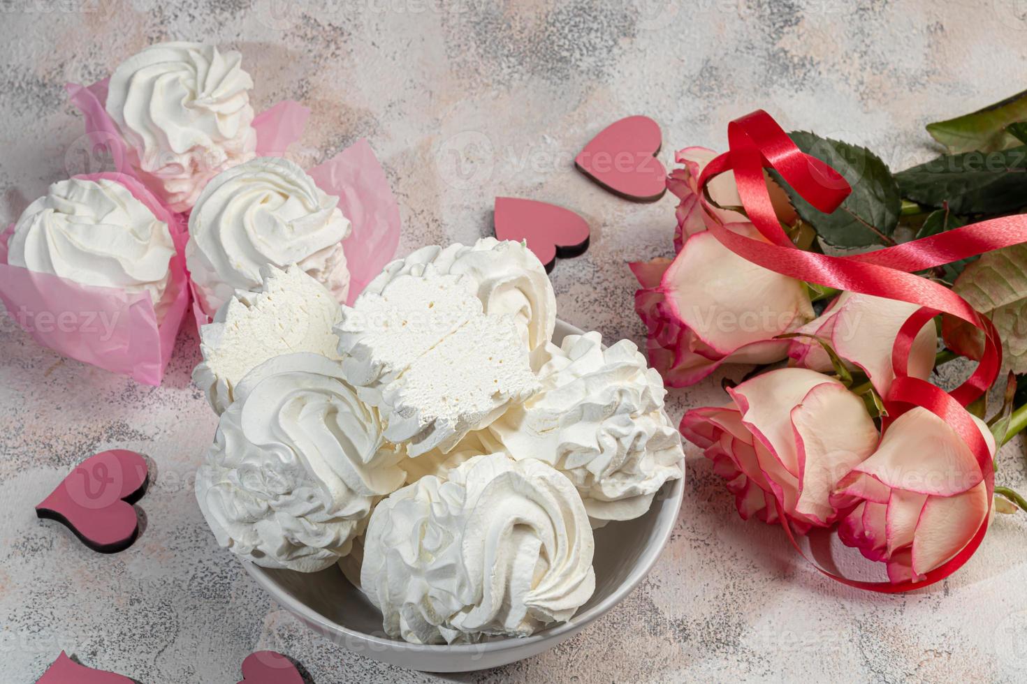 Handmade marshmallows on a light background in the form of roses, hydrangeas and tulips. There are flowers nearby. Women's day, Valentine's day. photo
