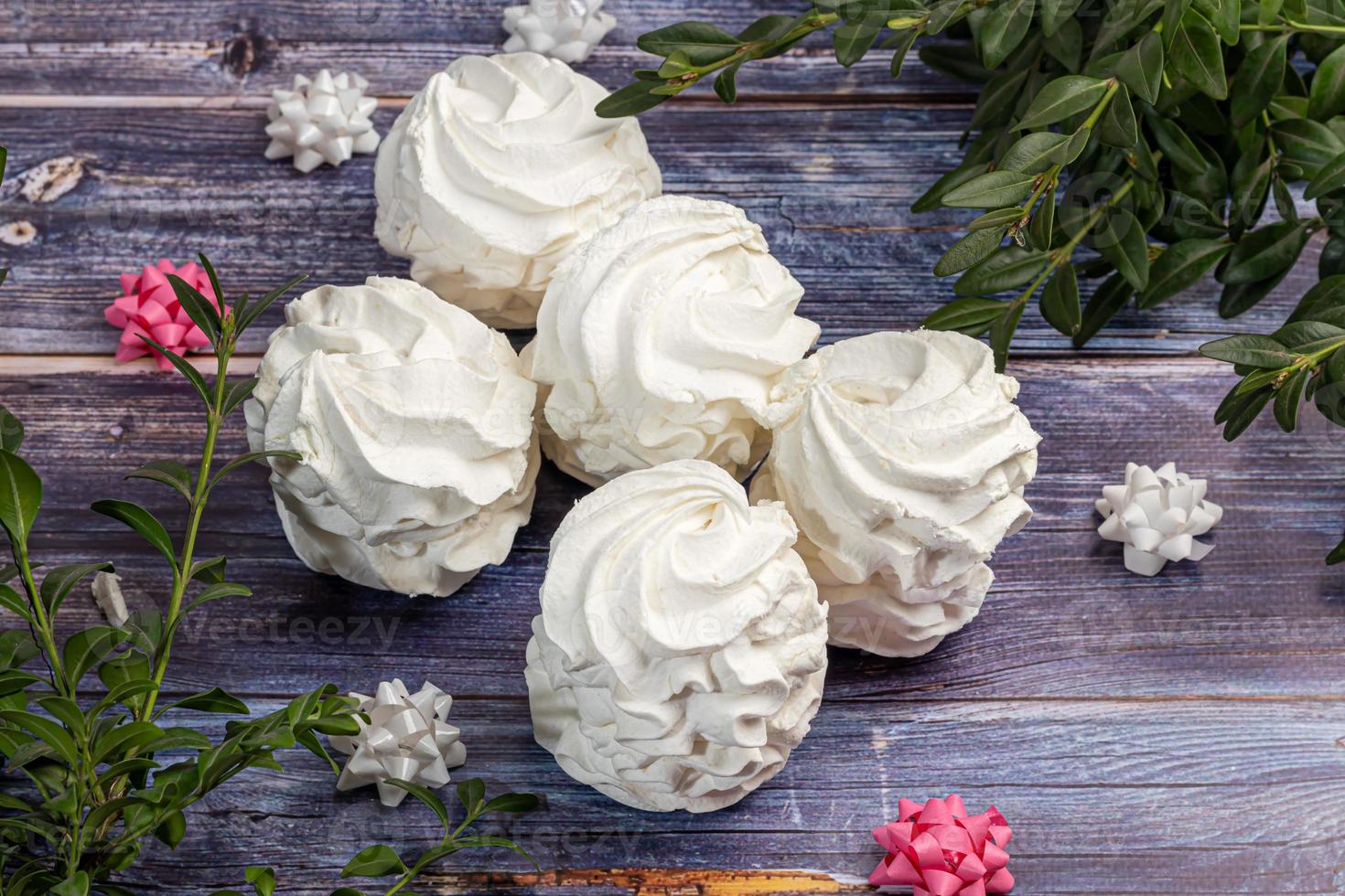 Handmade marshmallows on a light background in the form of roses, hydrangeas and tulips. There are flowers nearby. Women's day, Valentine's day. photo