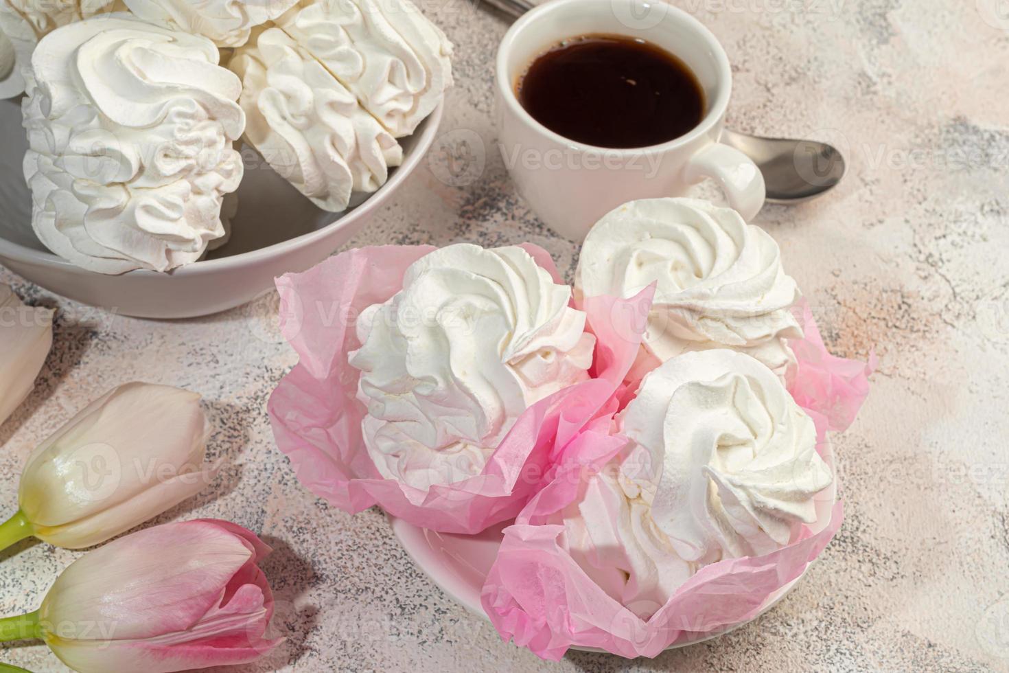 Handmade marshmallows on a light background in the form of roses, hydrangeas and tulips. There are flowers nearby. Women's day, Valentine's day. photo