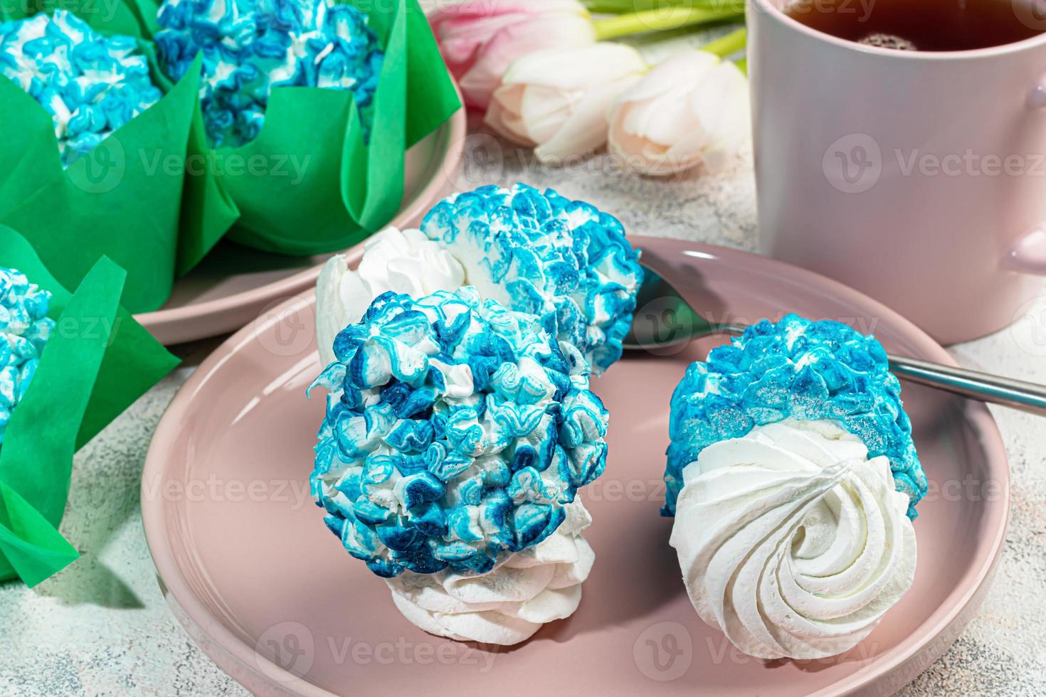 Handmade marshmallows on a light background in the form of roses, hydrangeas and tulips. There are flowers nearby. Women's day, Valentine's day. photo
