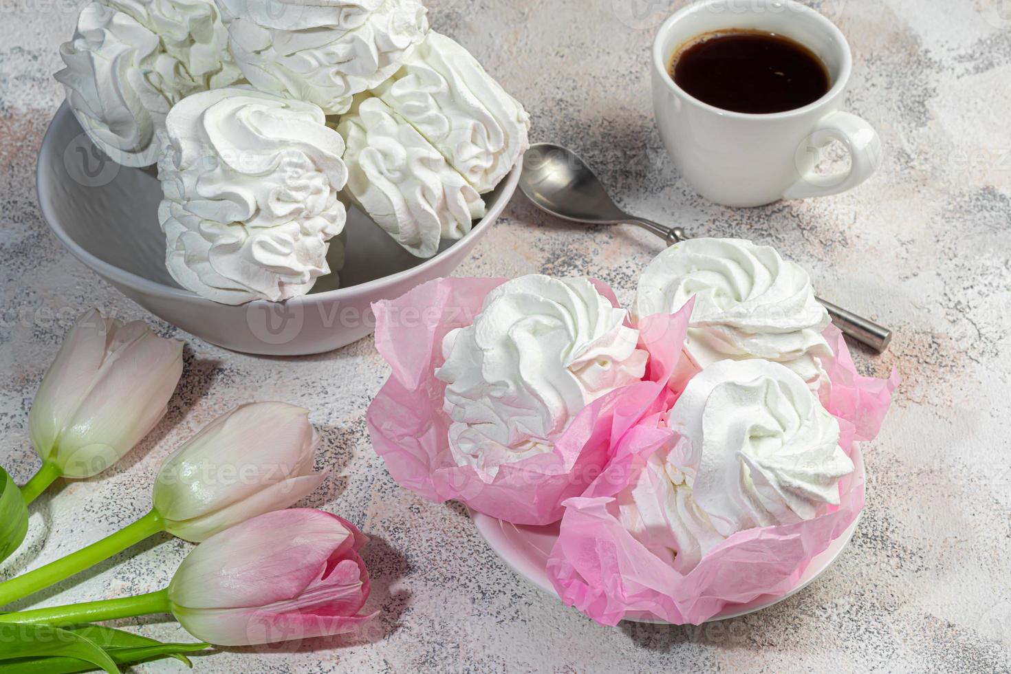 Handmade marshmallows on a light background in the form of roses, hydrangeas and tulips. There are flowers nearby. Women's day, Valentine's day. photo