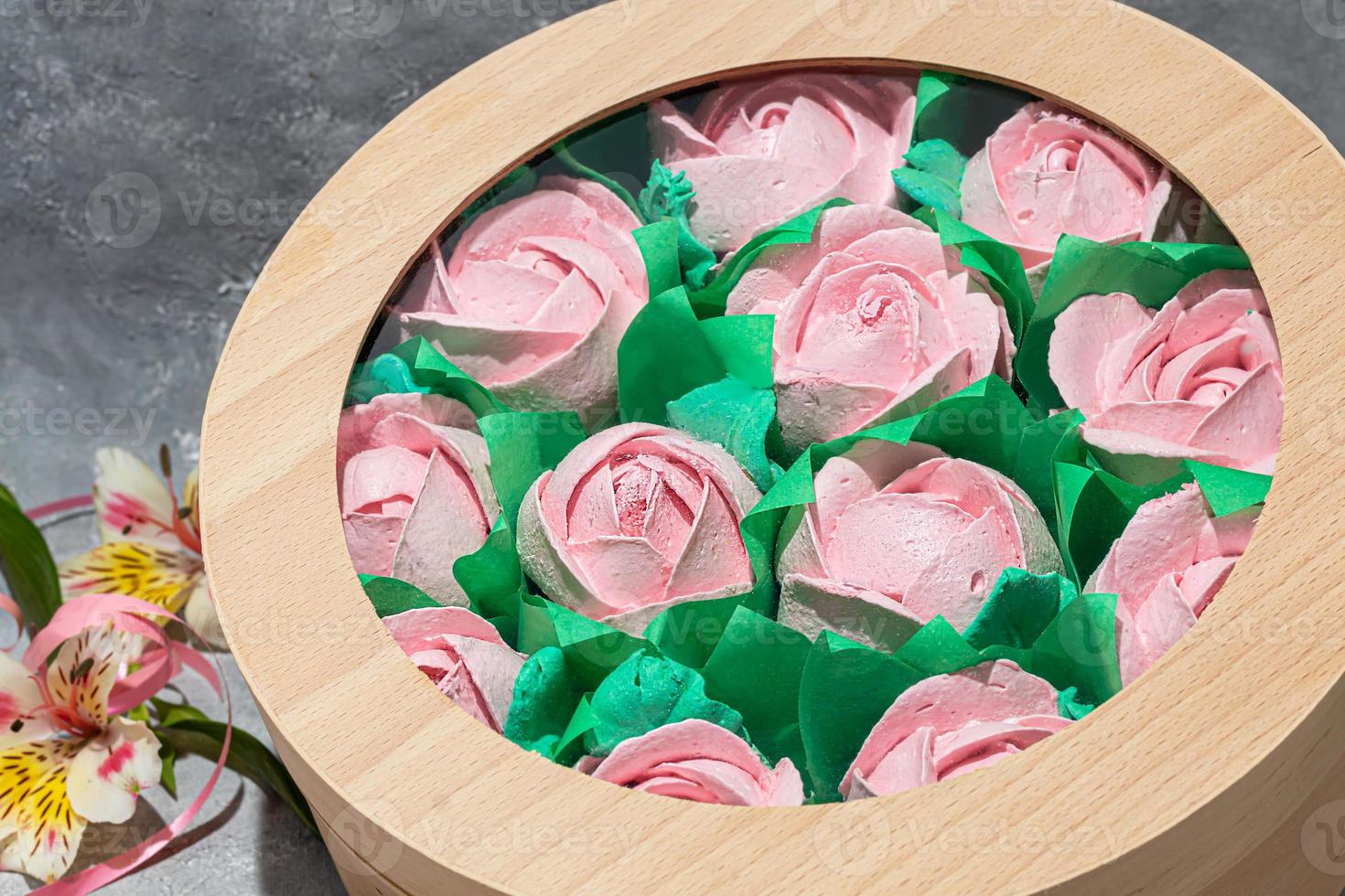 Handmade marshmallows in wooden packages on a light background with flowers. The concept of the holidays Women's Day and Valentine's Day. photo