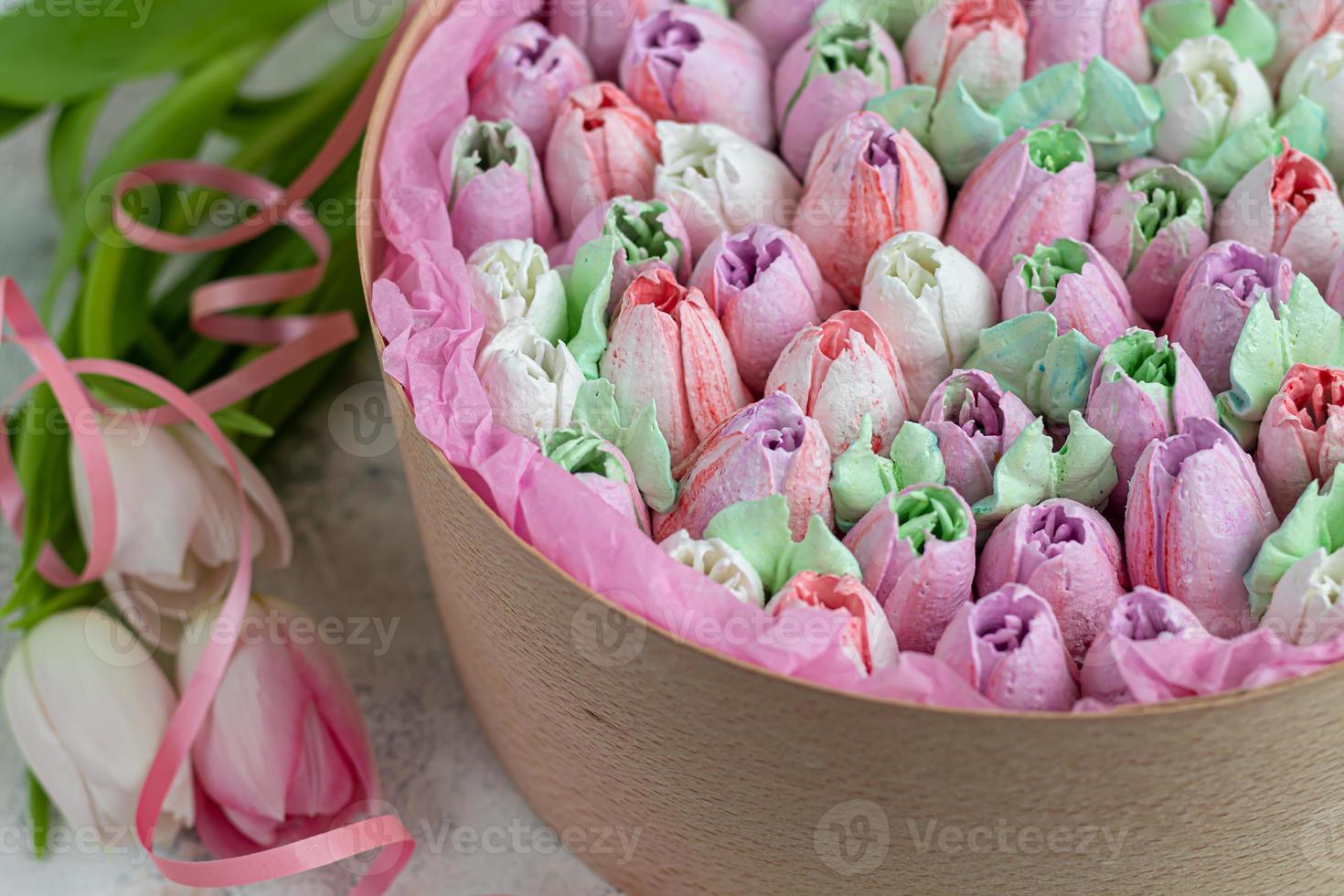 Handmade marshmallows in wooden packages on a light background with flowers. The concept of the holidays Women's Day and Valentine's Day. photo