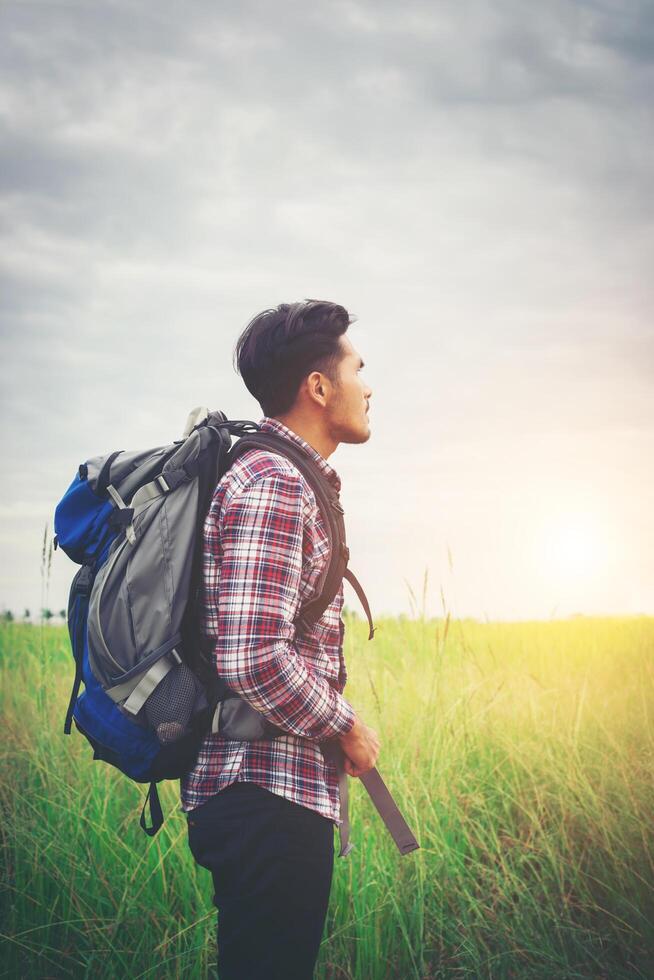 hombre hipster con una mochila sobre los hombros, hora de viajar, concepto de turismo. foto