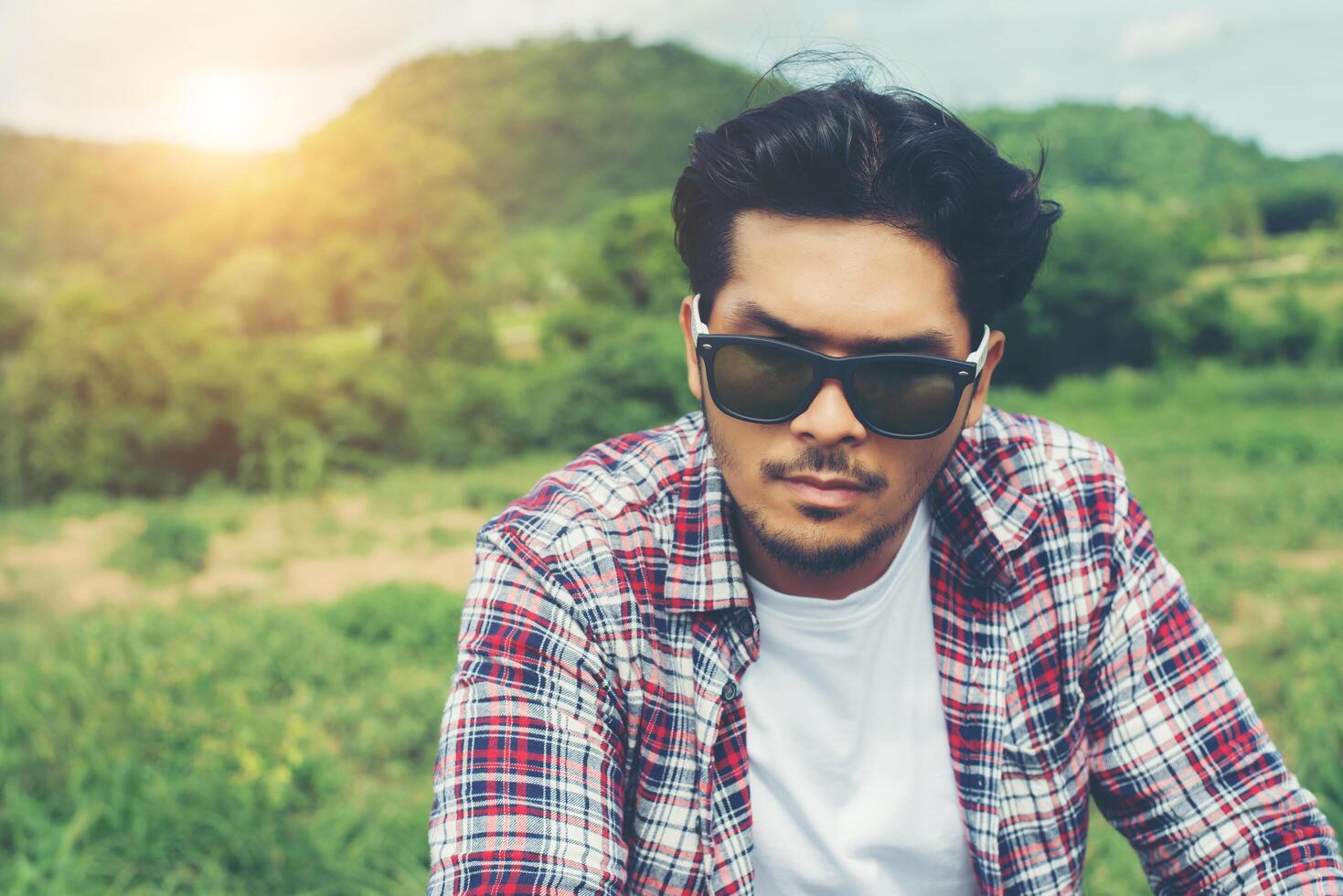 Young hipster man riding bike to the top of mountain enjoy with fresh breeze and nature behind the mountain view. photo