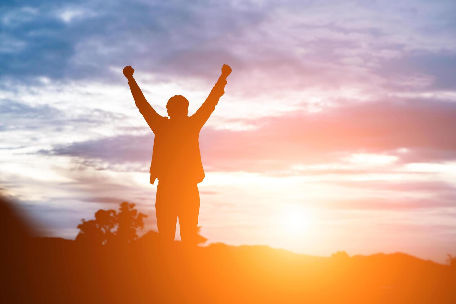 Raised arms man against beautiful sunset. photo