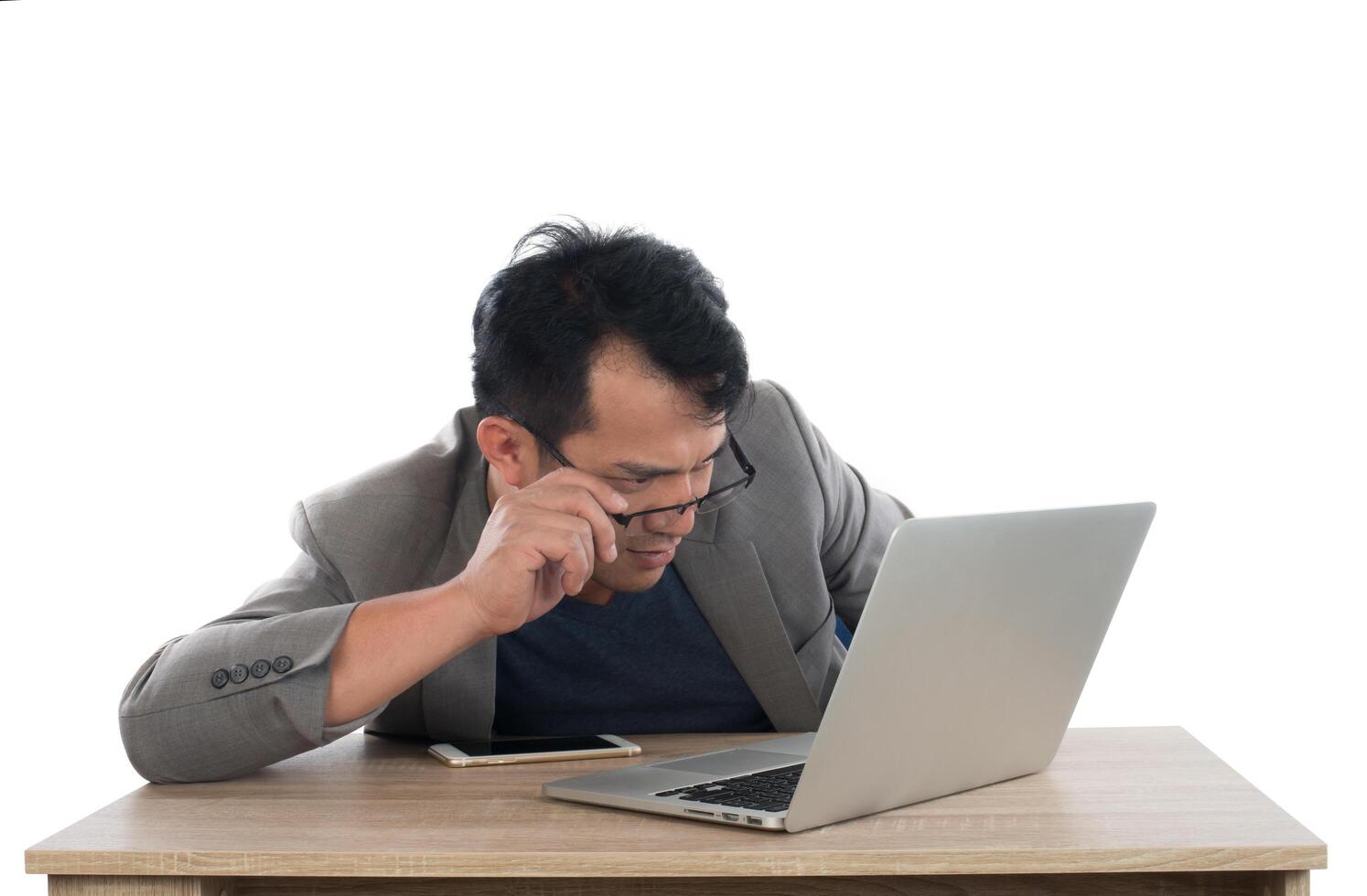 Stressed businessman work  with laptop sitting at table isolated on white background. photo
