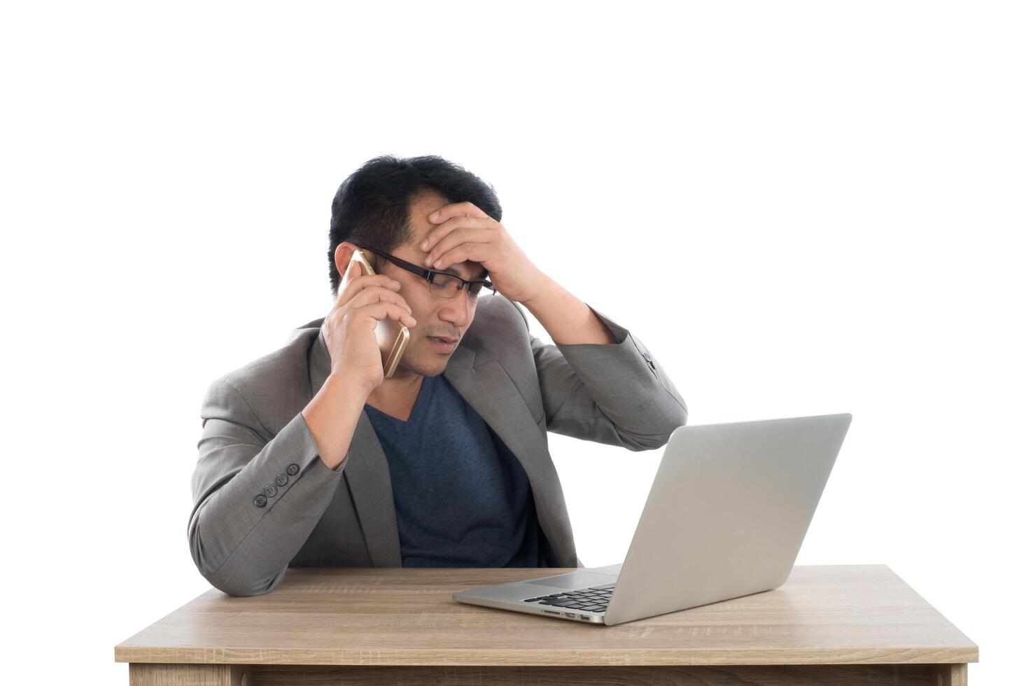 Stressed businessman talking on phone work  with laptop sitting at table isolated on white background. photo