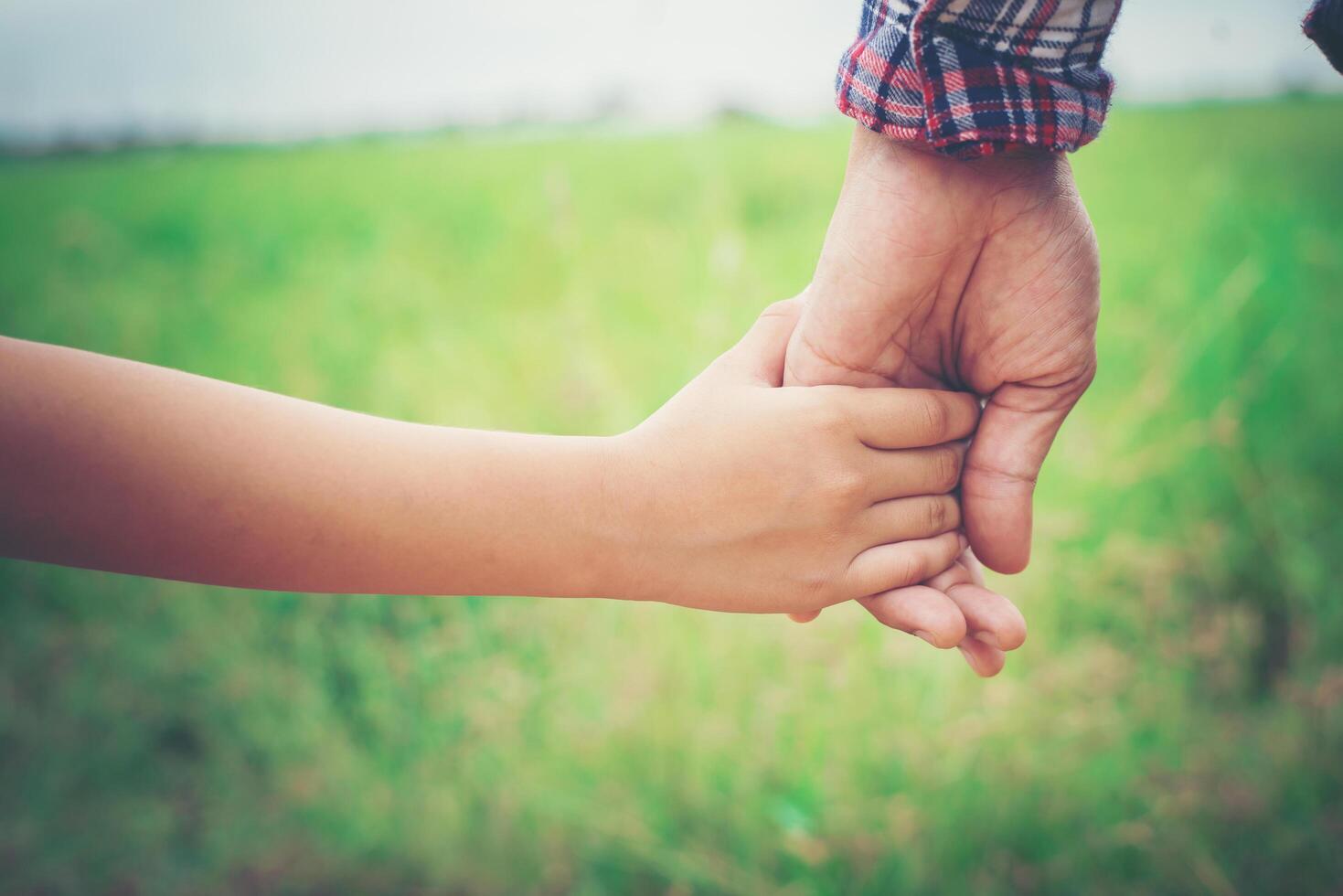 primer plano del padre sosteniendo la mano de su hija, tan dulce, tiempo en familia. foto