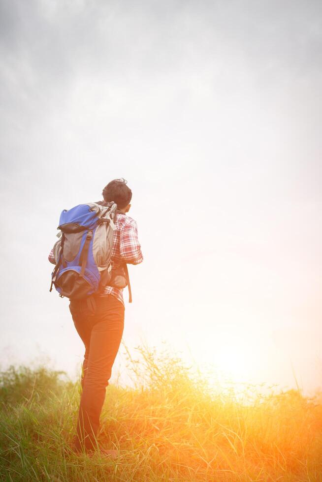 Young hipster man outdoor with backpack on his shoulder, Time to go traveling, Adventure with hiking. photo