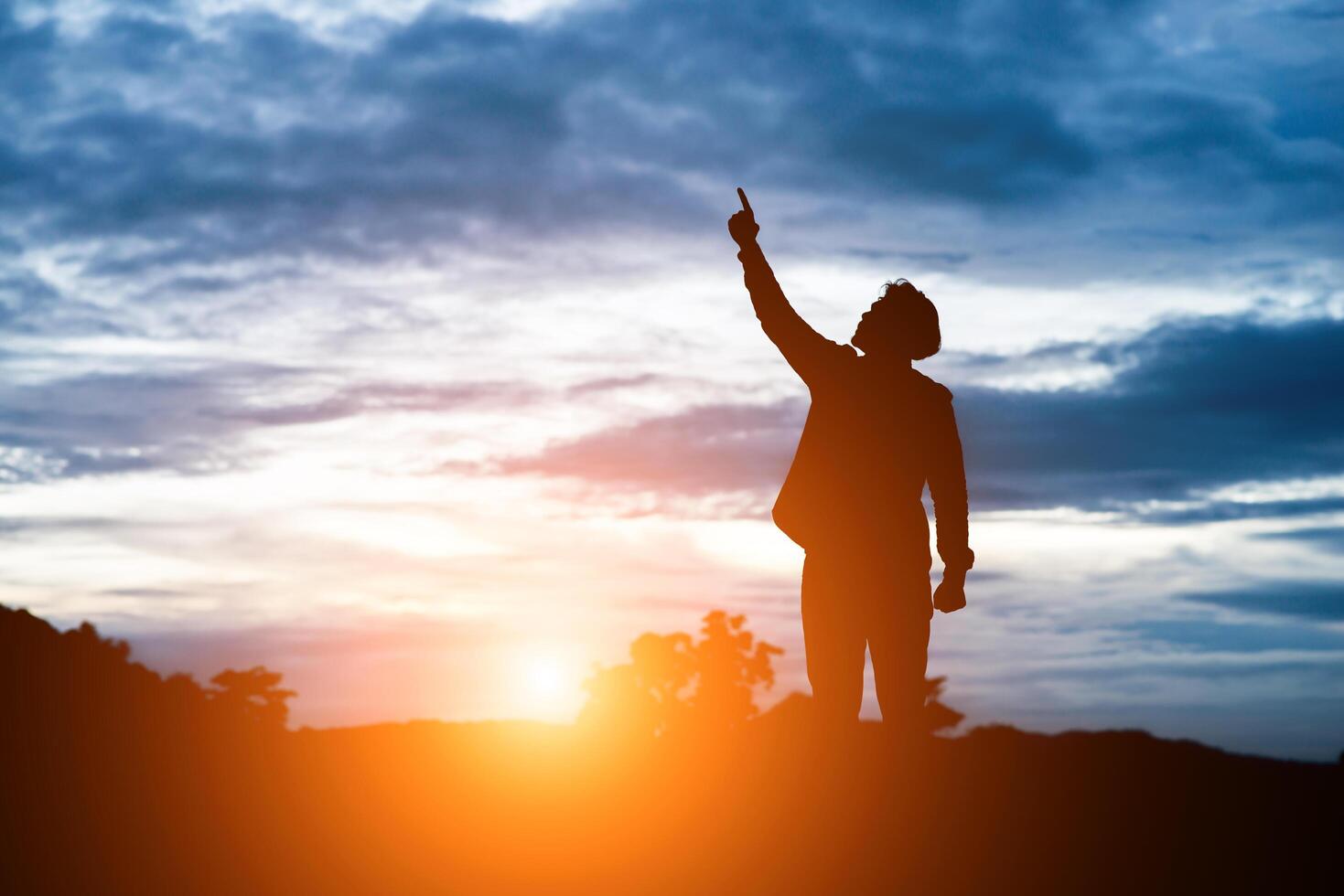 hombre de brazos levantados contra la hermosa puesta de sol. foto