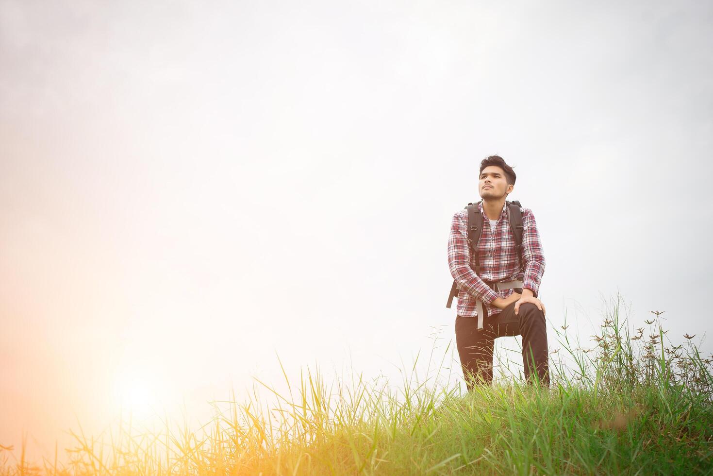 Portrait of young hipster man outdoor raising hands with backpack on his shoulder, Adventure tourism. photo