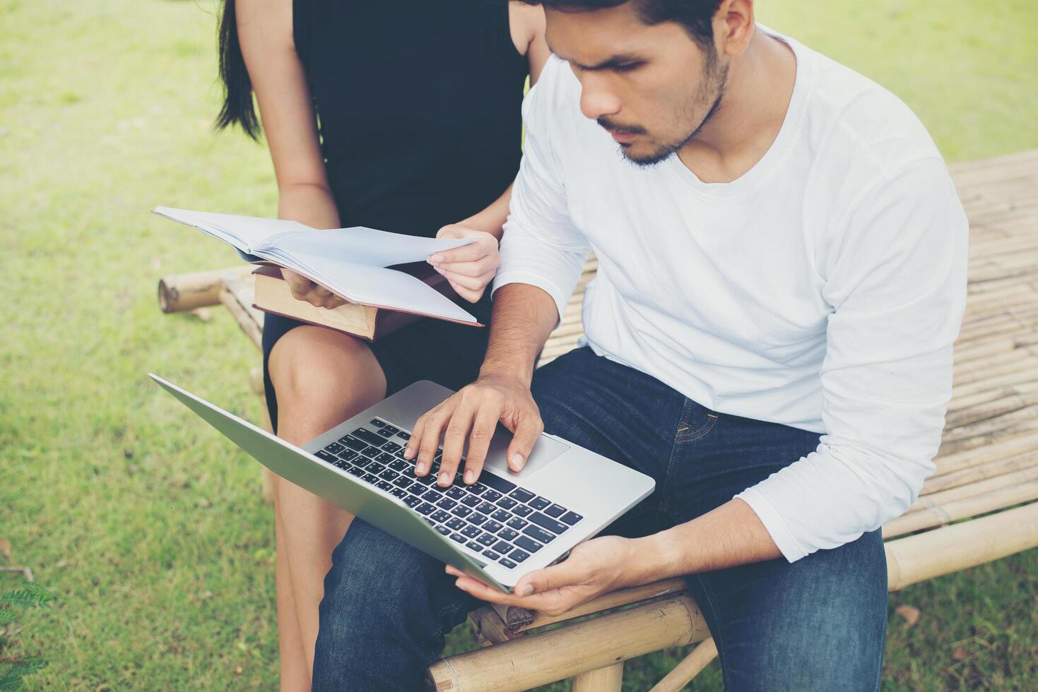 Young education couple practice together hand typing on laptop and reading book. photo