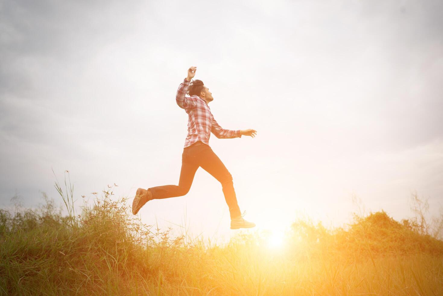 Hipster man jump up high, Freedom enjoying with the nature around. photo