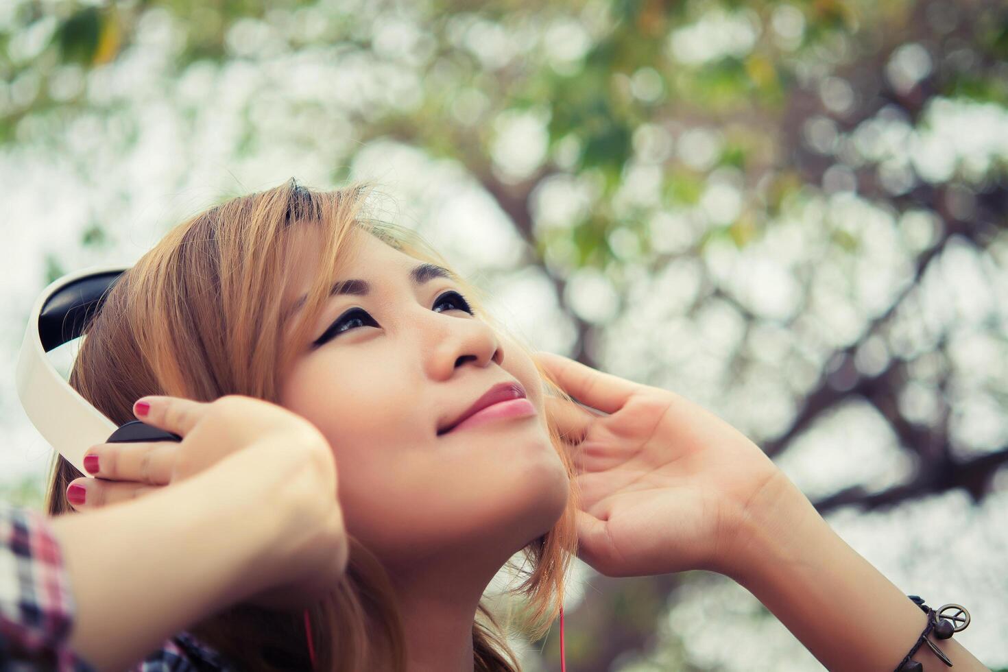 Young beautiful woman with headphones.listening to loud music outdoors and enjoy. photo