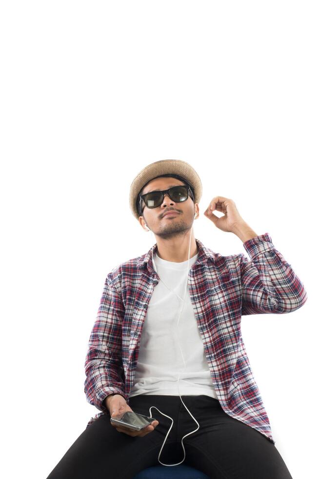 Young hipster man in earphones holding smartphone isolated on the white background. photo