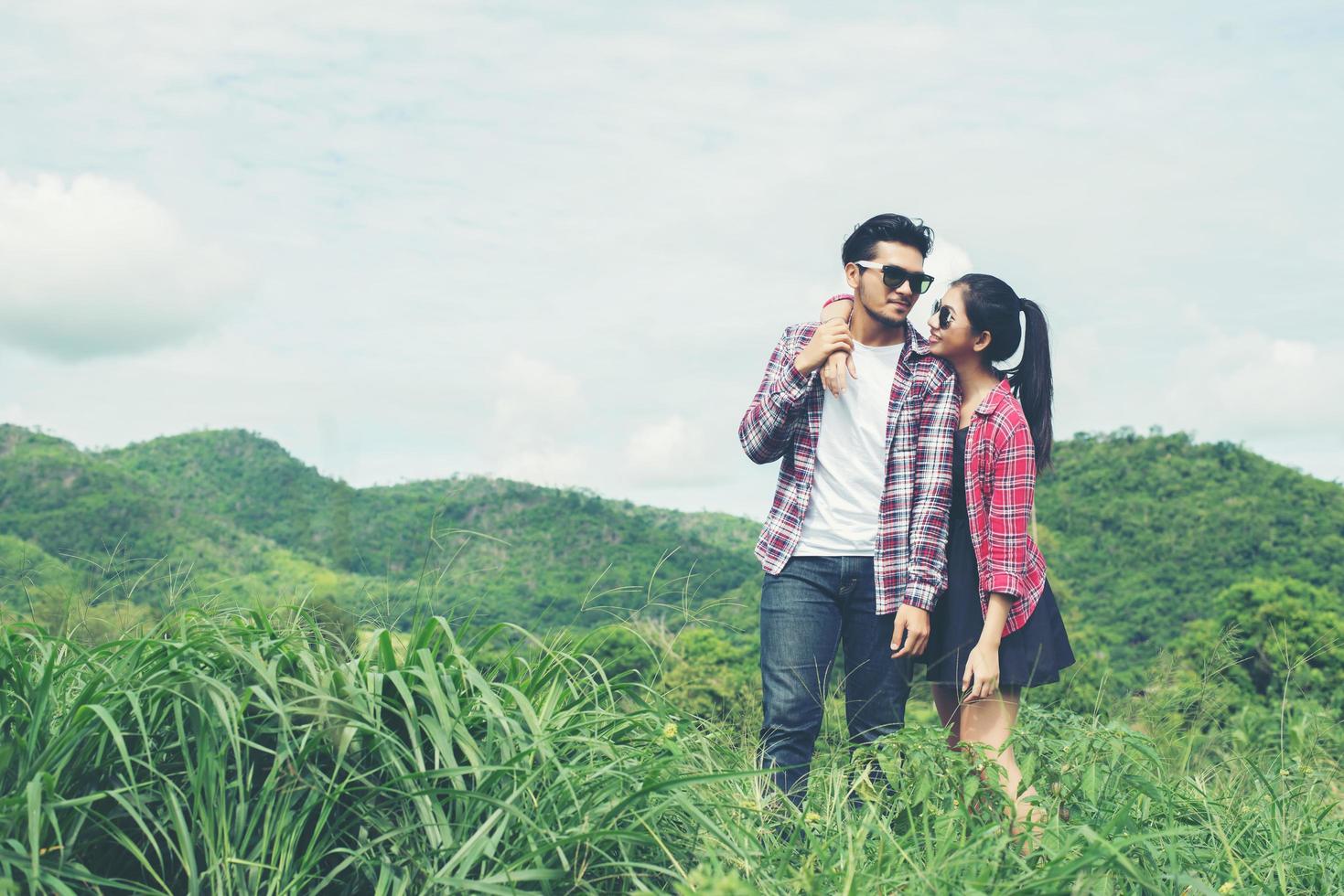 Young hipster couple holding hands walking on the meadow relaxing and natural atmosphere is very natural. photo