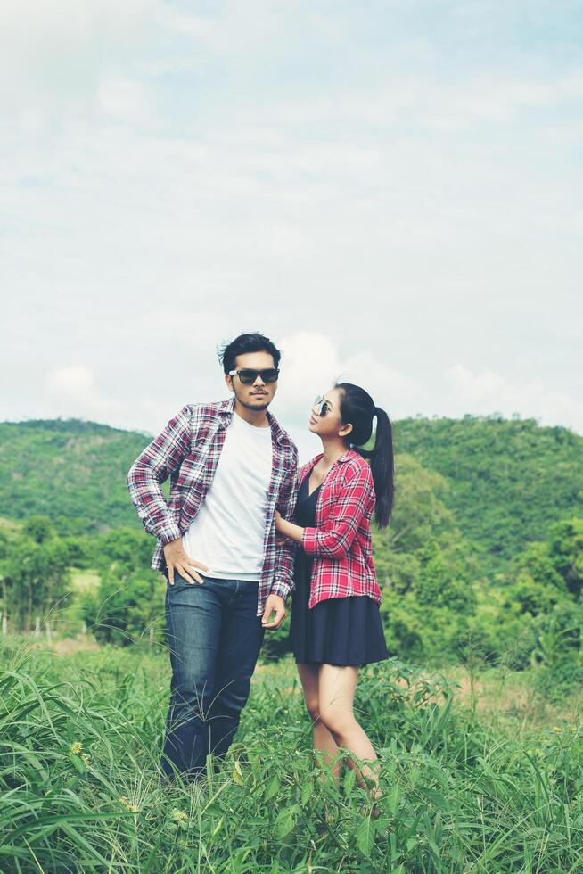 Young hipster couple holding hands walking on the meadow relaxing and natural atmosphere is very natural. photo