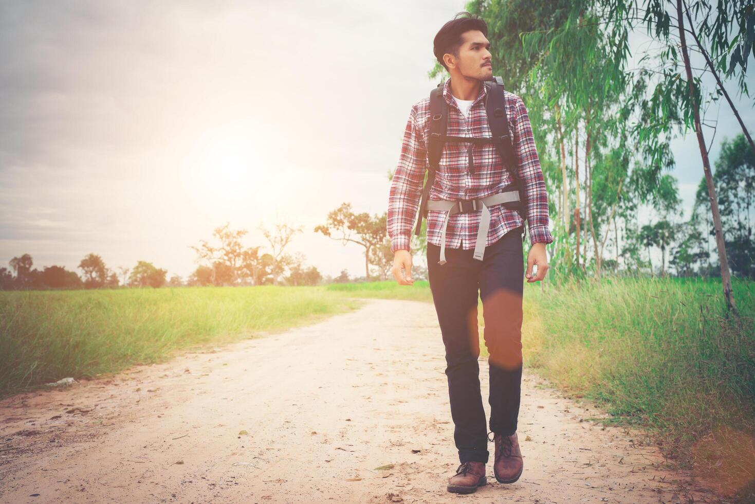 Young happy hipster traveler walking overcome big way smiling looking away, adventure travel and discovery. photo