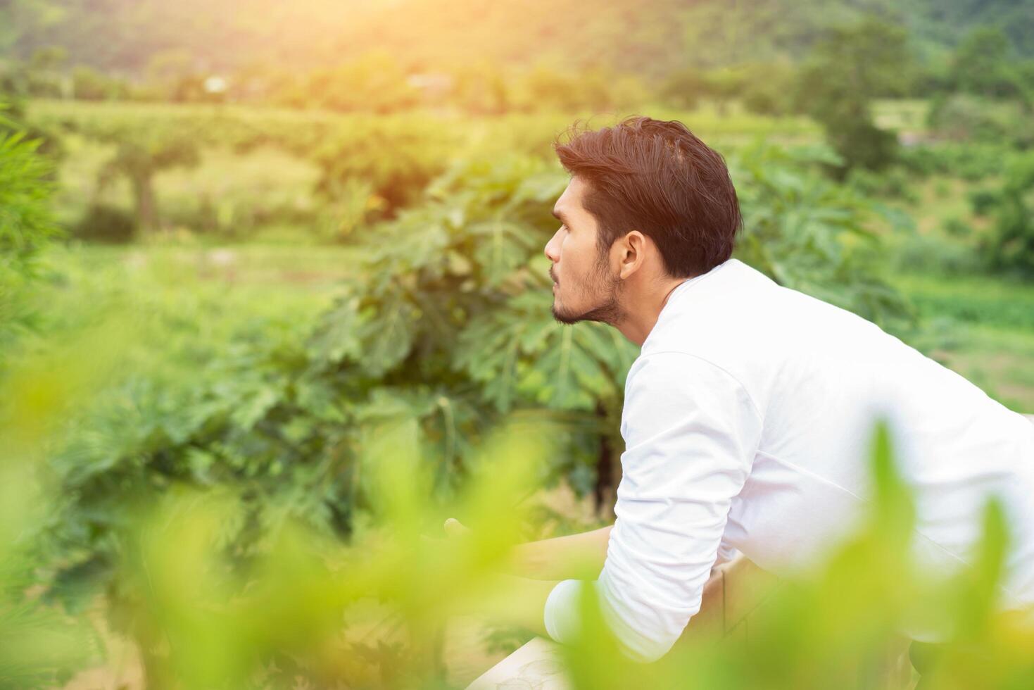 Young hipster man taking rest, smoking cigarette with nature and fresh breeze. photo
