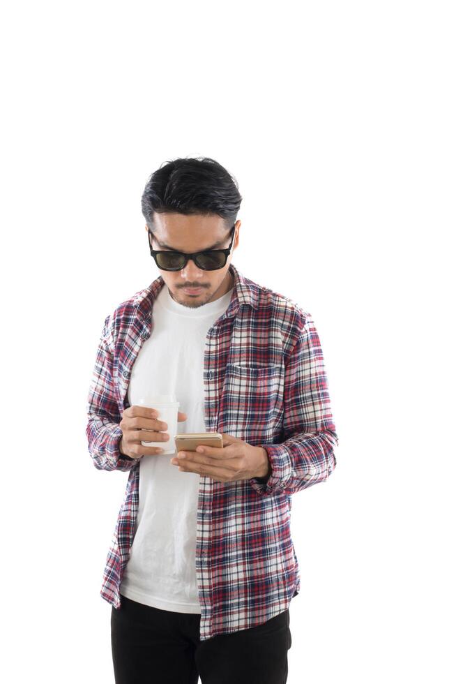 Young hipster man looking at his smart phone while text messaging isolated on white background. photo