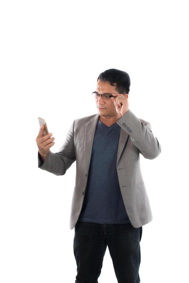 Handsome businessman and glasses standing and looking on mobile phone over white background. photo