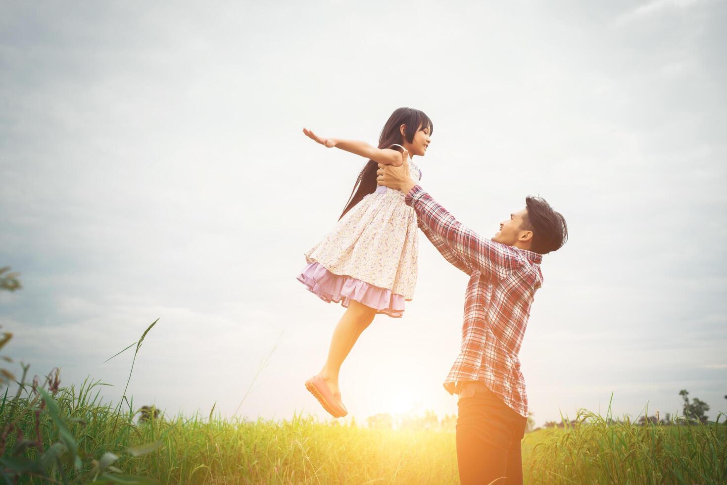 Daddy carrying his daughter with nature and sunlight, enjoyment family. photo