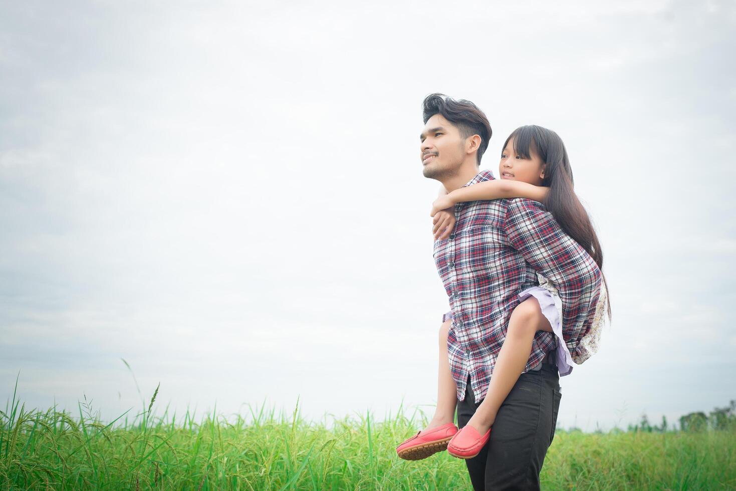 feliz padre y niña jugando en el campo de los prados, disfrutando juntos. foto