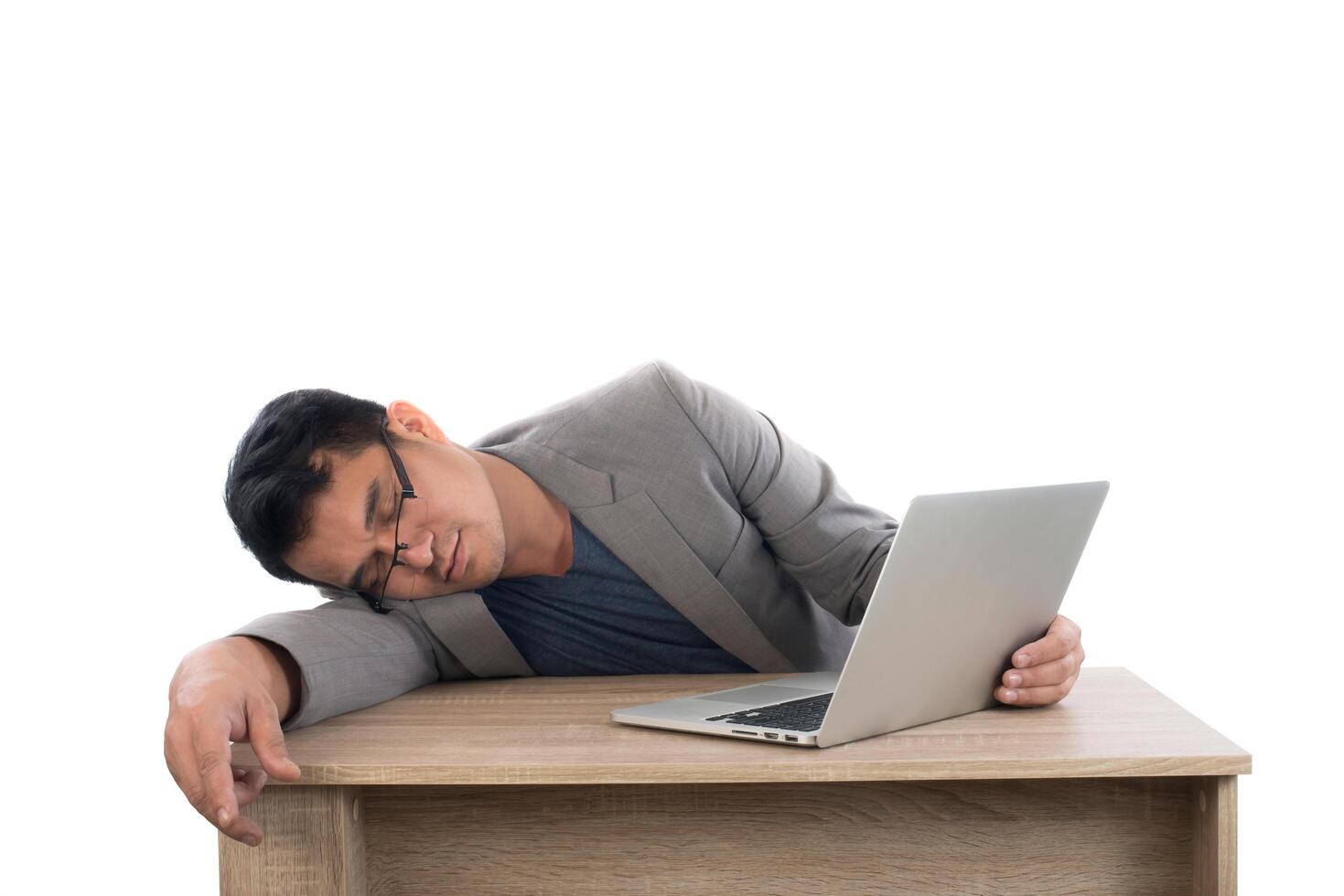 Businessman sleeping next to his laptop computer with white background. photo