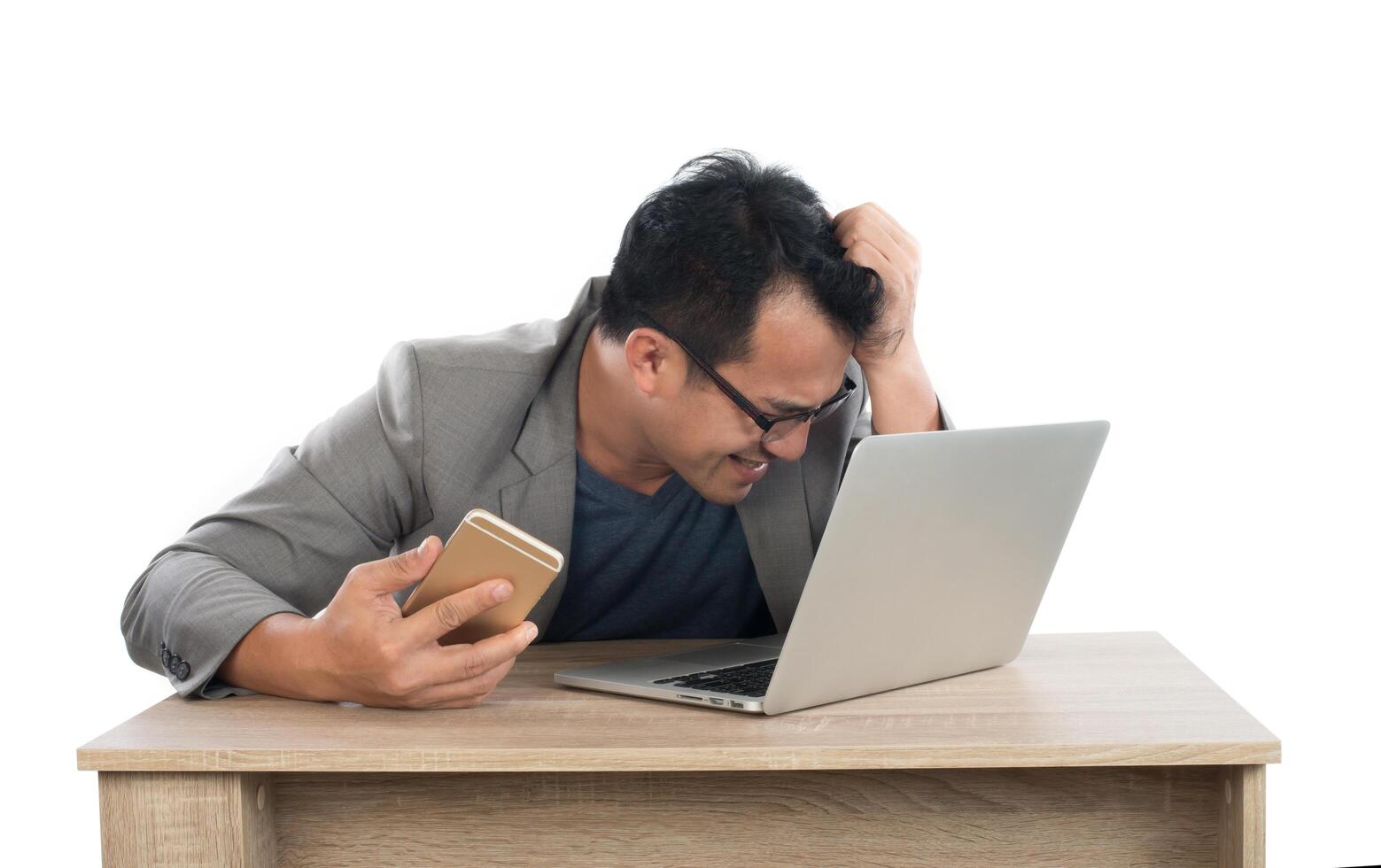 Stressed businessman work  with laptop sitting at table isolated on white background. photo