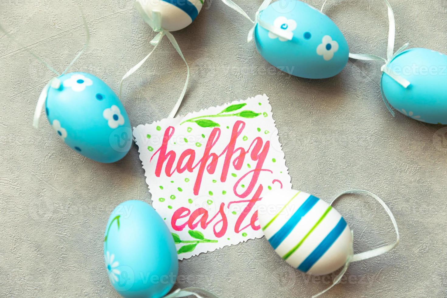 Happy Easter concept. Preparation for holiday. Blue Easter eggs Inscription HAPPY EASTER letters text on concrete stone grey background. Flat lay top view copy space. photo
