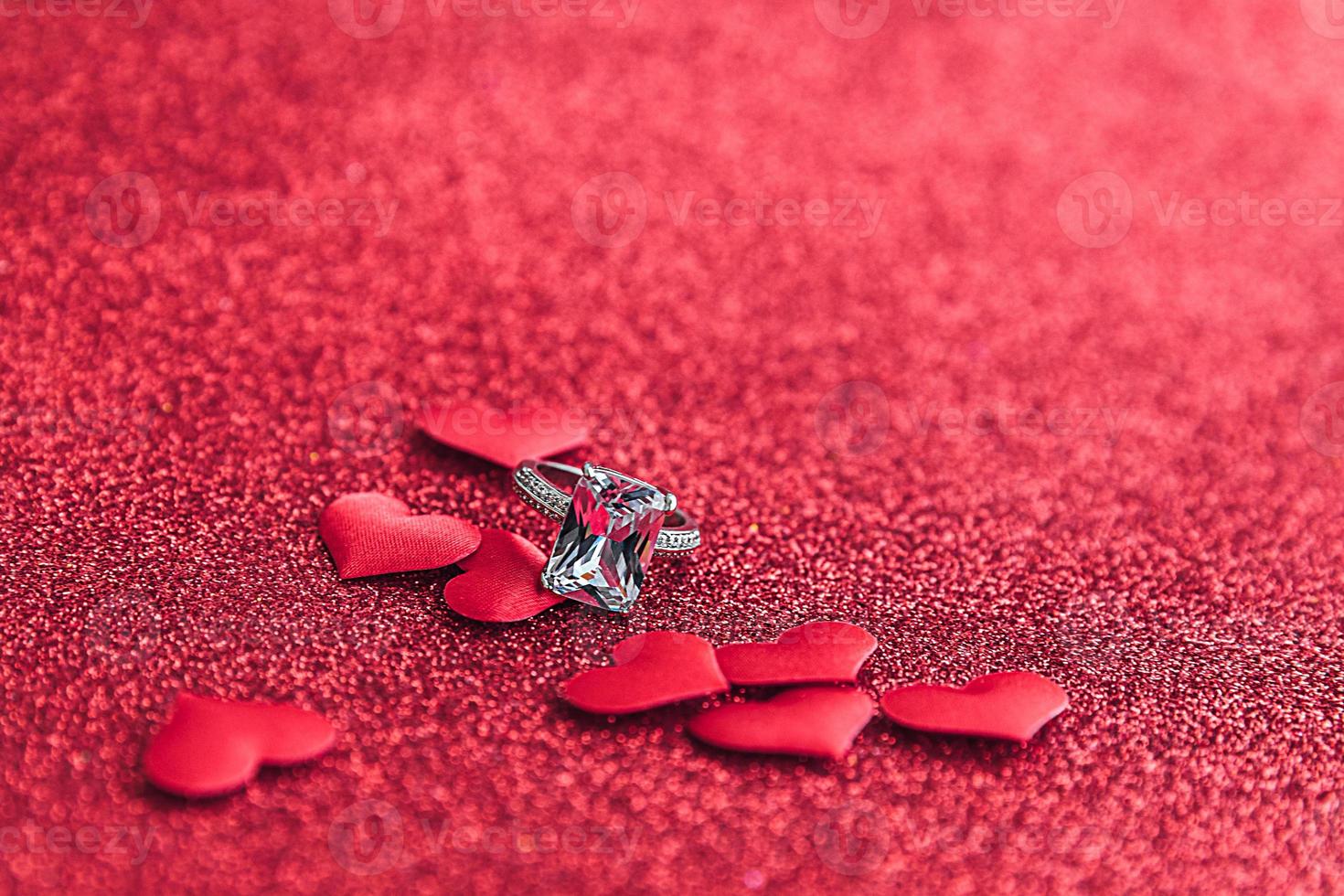 Te casarías conmigo. anillo de bodas y muchos corazones rojos sobre fondo de brillo rojo. concepto de boda de propuesta de matrimonio de compromiso. S t. postal del día de san valentín. pancarta en el día de san valentín. foto