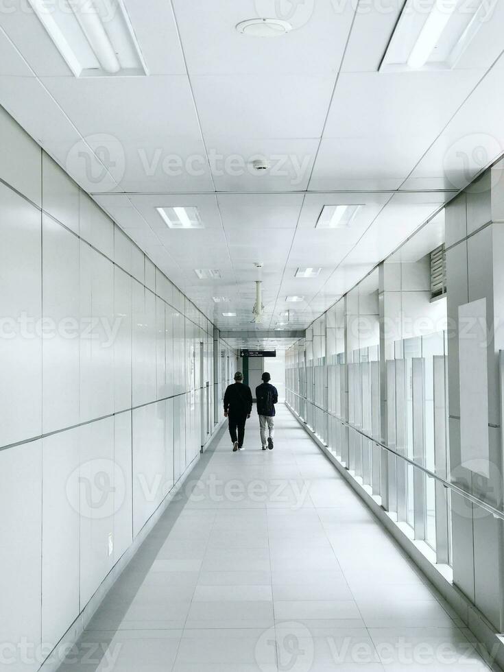 Two Best Friends Walk Through Station Hallway During The Day photo
