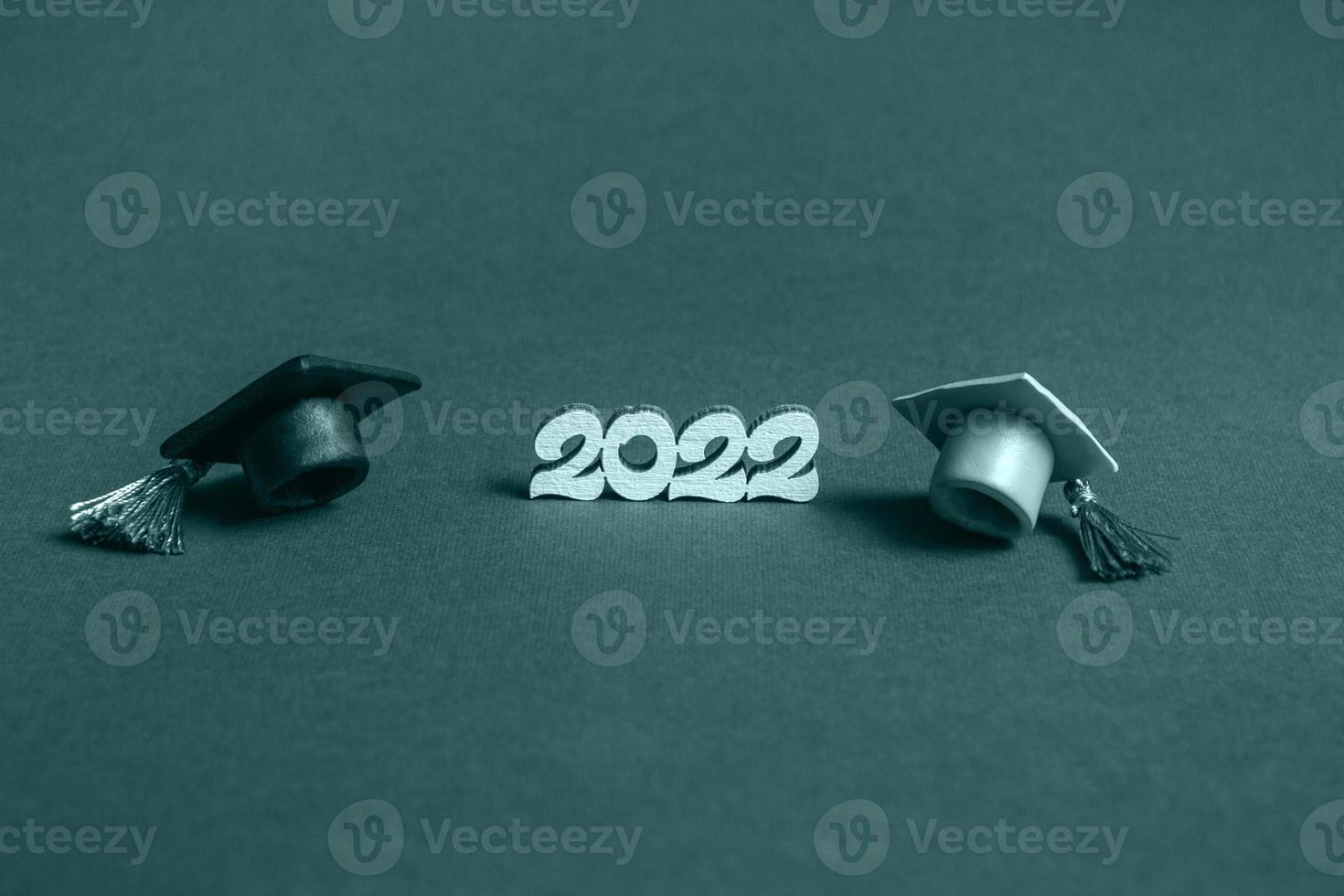 Graduation cap and numbers 2022 on blue background, closeup with copy space. Medical education concept. photo