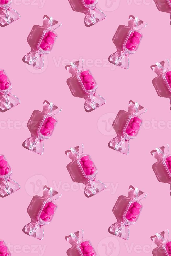 Transparent candy shaped box with sweet heart lollipops with hard shadow on pink background with copy space. The concept of Valentines day, mothers day. Pattern vertical format photo