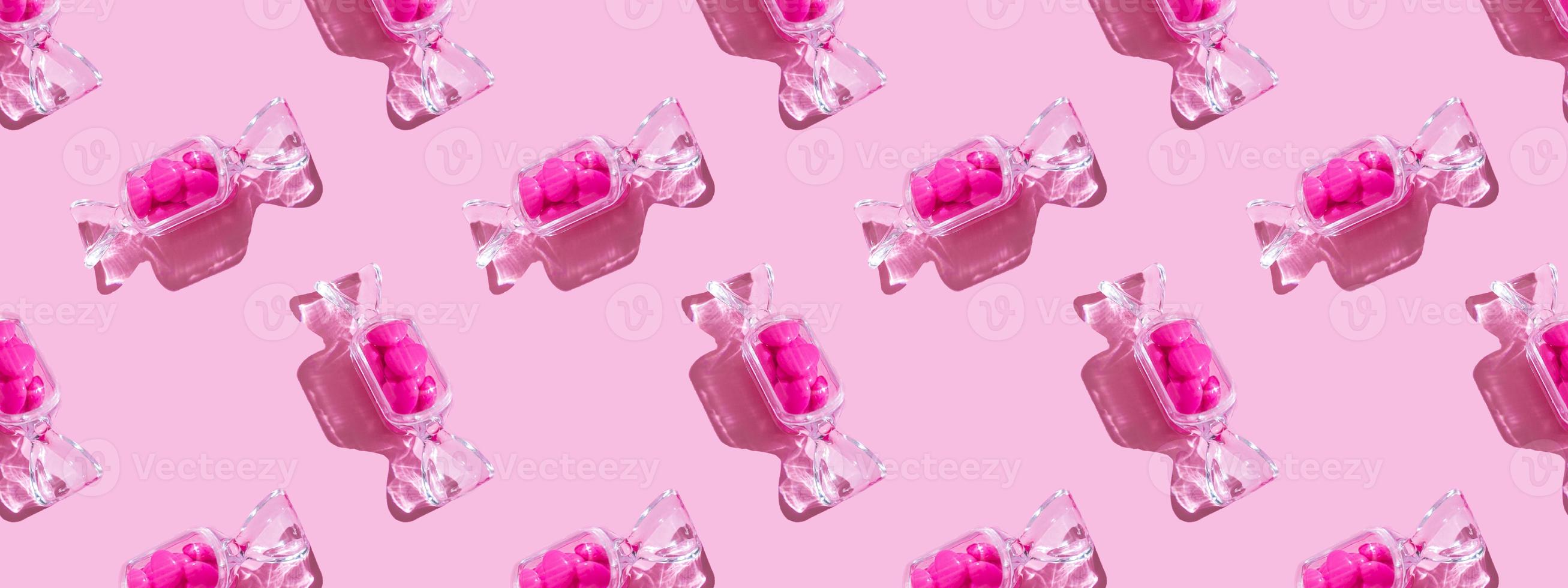 Transparent candy shaped box with sweet heart lollipops with hard shadow on pink background copy space. The concept of Valentines day, mothers day. Banner. pattern photo