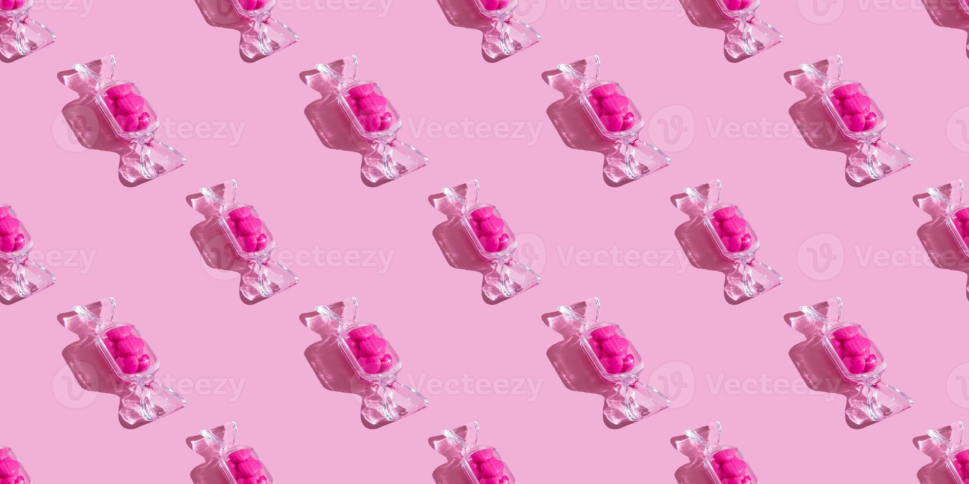 Transparent candy shaped box with sweet heart lollipops with hard shadow on pink background with copy space. The concept of Valentines day, mothers day. Banner photo