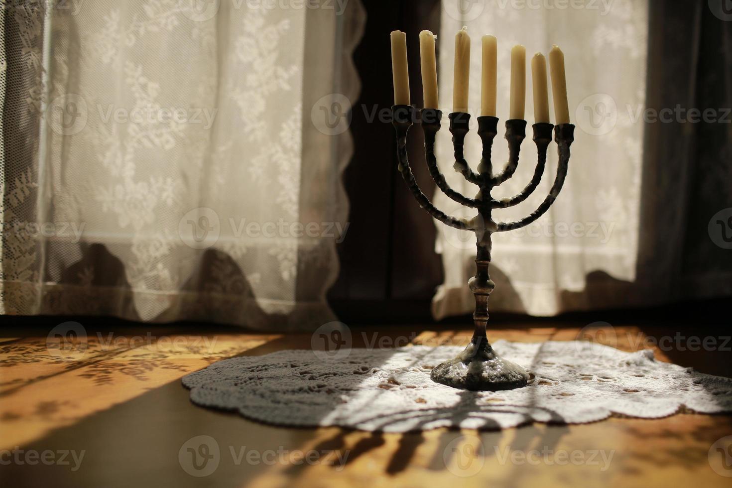 Candles in vintage copper candle holder on wooden table near the window in country house interior photo
