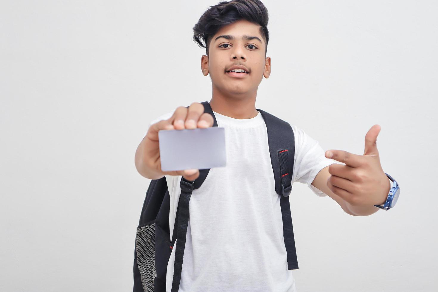 estudiante universitario indio que muestra la tarjeta sobre fondo blanco. foto