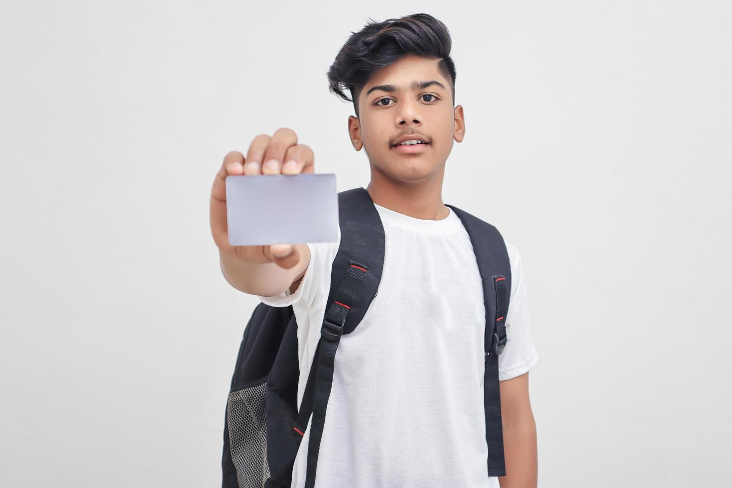 estudiante universitario indio que muestra la tarjeta sobre fondo blanco. foto