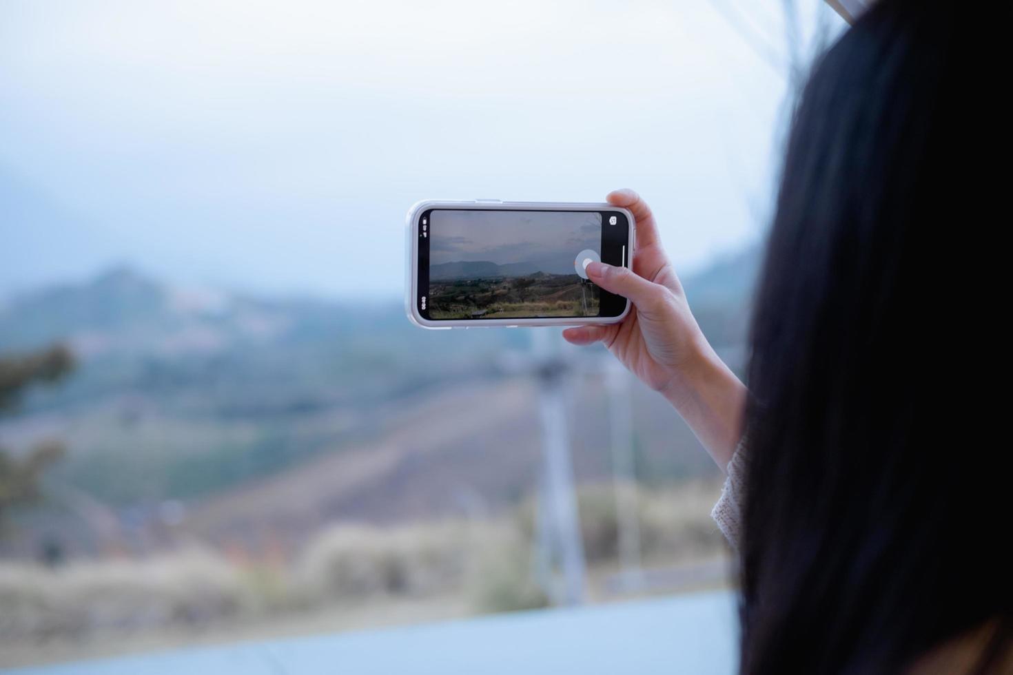 mujer que usa un teléfono inteligente toma una foto en khao kho, tailandia