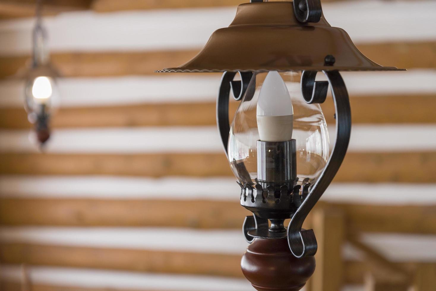 Old hinged electric lantern inside a wooden house. photo