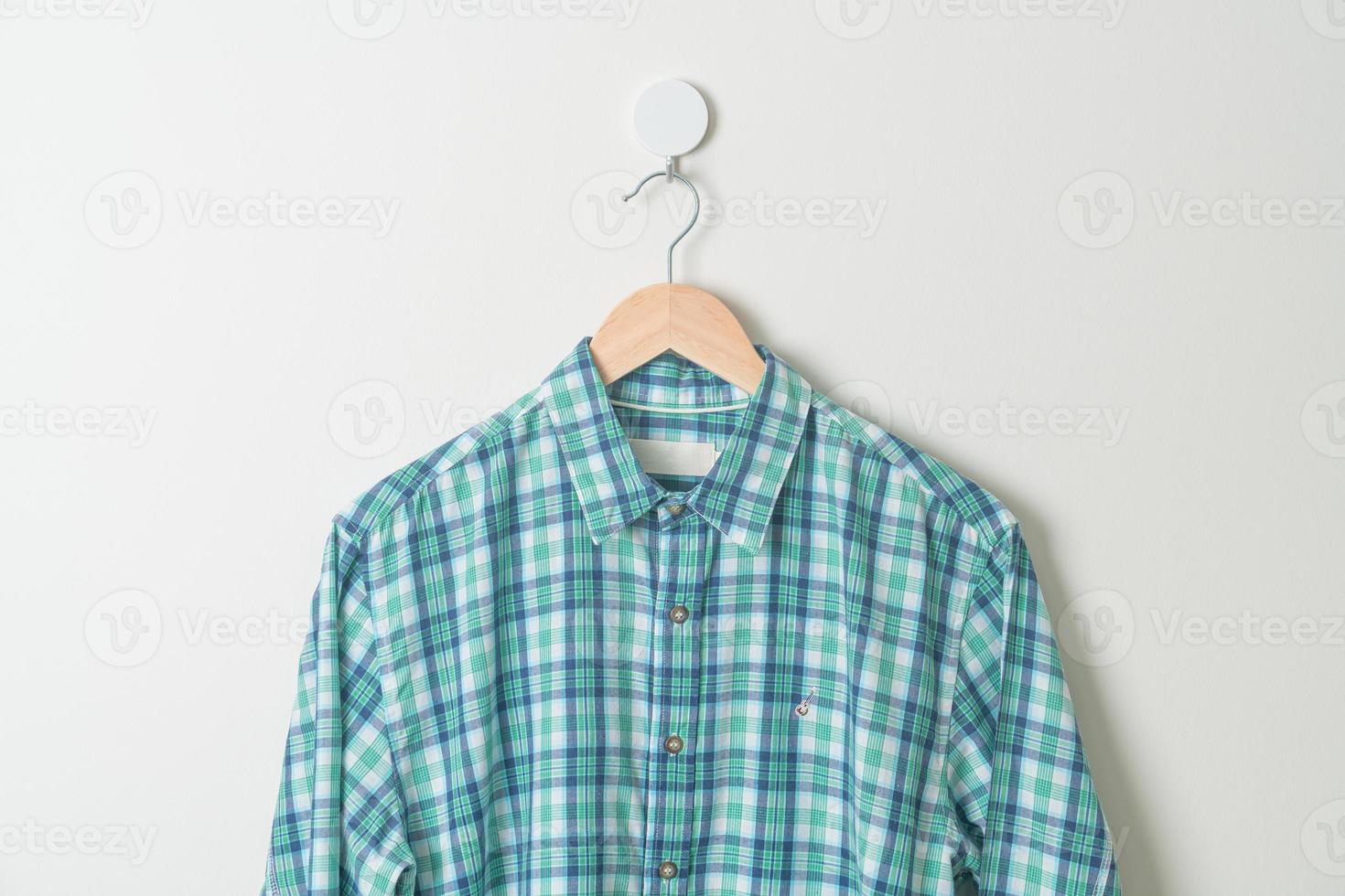 hanging shirt with wood hanger on wall photo