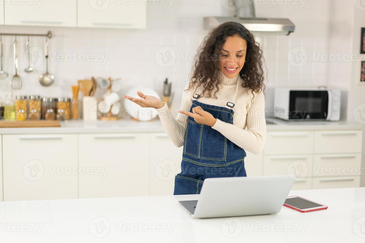 Latin woman shooting video and cooking at the kitchen photo