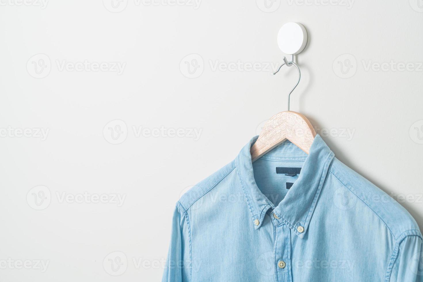 hanging shirt with wood hanger on wall photo